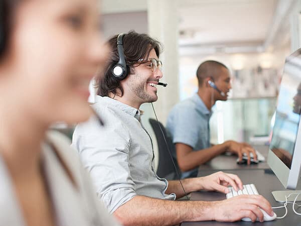 Business U Caa S Features 600x450 Multiple people with headsets talking on phone and looking at computers